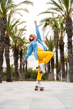 Beautiful red haired young woman with rollerskates having fun outdoors