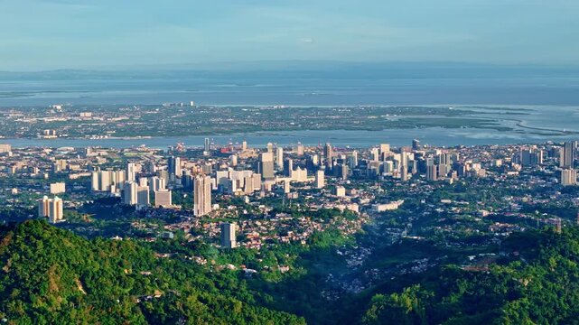 Right to left aerial pan of Cebu City skyline with Mactan Channel and coastal urban landscape in the Philippines
