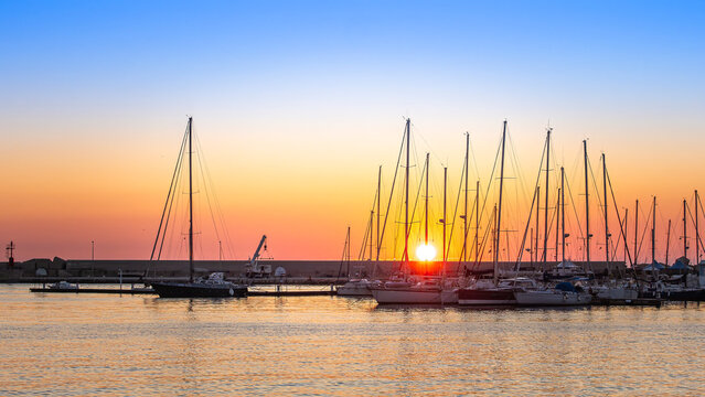Sailboats docked in Sciacca harbor at sunset