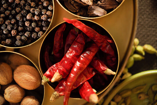 Kashmiri Mirch with other species, Dried red chili peppers in bowl top view, whole red chilli spice close up with black pepper and nutmeg, Indian cooking ingredient, Lal mirch, Indian spices