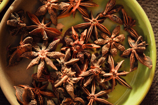Star anise (Chakri Phool) in green bowl top view, whole dried star anise spice close up, Indian and Asian cooking ingredient, Chakra Phool
