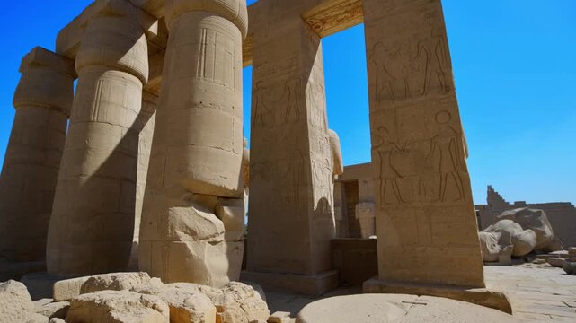 Ruins of Ramesseum mortuary temple with giant Ramesses II Osiride statues. Upward view of massive carved columns and hieroglyphic lintels at Ramesseum temple Luxor Egypt.