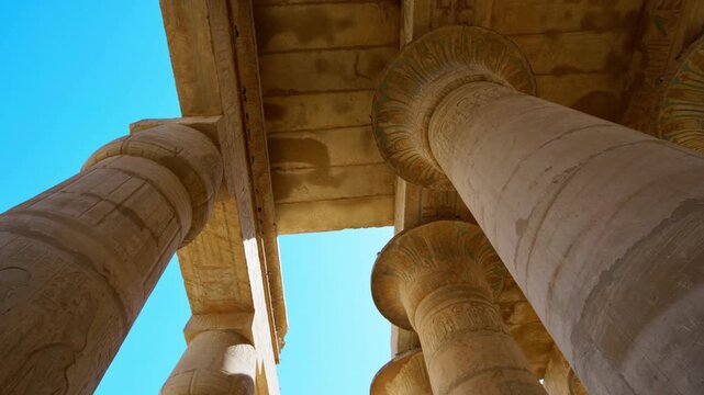 Ruins of Ramesseum mortuary temple with giant Ramesses II Osiride statues. Upward view of massive carved columns and hieroglyphic lintels at Ramesseum temple Luxor Egypt.
