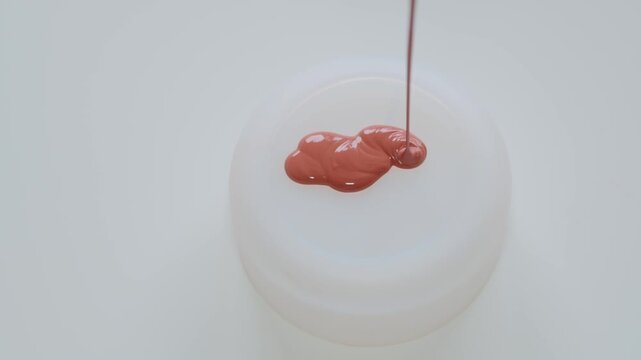 Red Paint Dripping Onto White Jar Lid Close-Up Minimal Glossy Liquid Pour Texture
