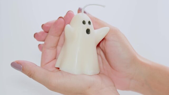 Female Hands Holding Cute White Ghost Candle For Halloween Decor And Seasonal Home Decoration