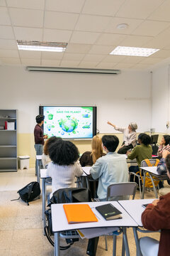 Students attending a lecture on environmental sustainability and saving the planet in a college or high school classroom setting