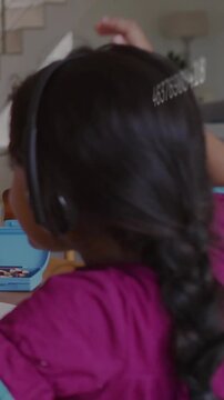 Student with headset raising right arm, changing numeric overlays, reaching blue box for school art