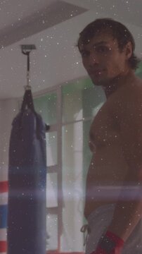 Vertical video: Boxer shifting, turning head by bag, red wraps, lensflare overlay, preparing