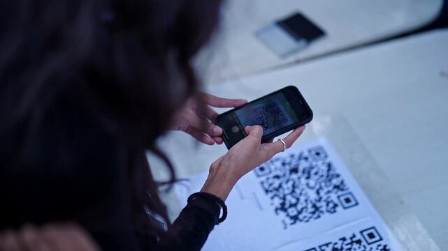 Closeup of a girl using a smart phone to scan a QR code to access information