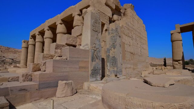 Ruins of Ramesseum mortuary temple with giant Ramesses II Osiride statues. It is located in the Theban necropolis in Upper Egypt, across the River Nile from the modern city of Luxor. Egypt.