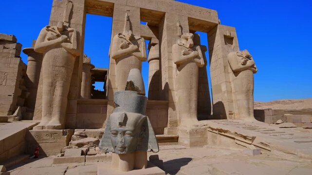 Ruins of Ramesseum mortuary temple with giant Ramesses II Osiride statues. It is located in the Theban necropolis in Upper Egypt, across the River Nile from the modern city of Luxor. Egypt.