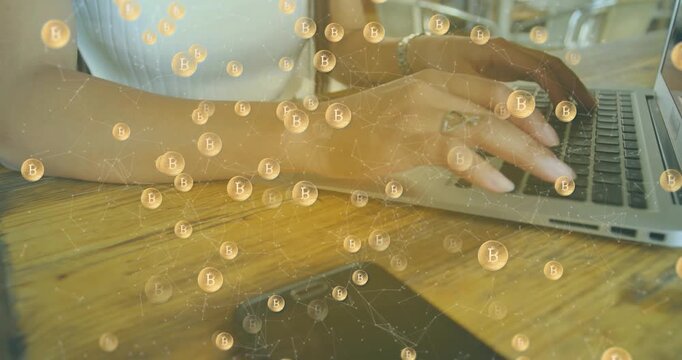 Animation of bitcoin symbols against mid section of a woman using a laptop at office