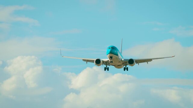 Jet flying through strong crosswind with visible tilt. Airliner facing gusty winds while moving in cloudy sky. Passenger aircraft descending with landing gear extended. Twin engine plane approaching