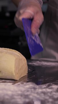 Cutting pie dough. A woman cuts pie dough in the kitchen.