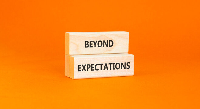 Beyond expectations words symbol. Concept words Beyond expectations on beautiful wooden blocks. Beautiful orange background. Business and Beyond expectations words concept. Copy space.