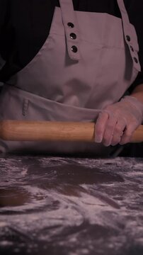 Kneading the pie dough. A woman rolls out the dough in the kitchen.