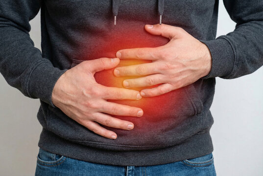 Homem segurando o est&ocirc;mago com dor intensa. Ponto vermelho brilhante no abd&ocirc;men indicando inflama&ccedil;&atilde;o, indigest&atilde;o ou problema de sa&uacute;de. Conceito m&eacute;dico.