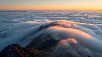Fototapeta premium Aerial view of heavy morning fog rolling over dark mountain peaks