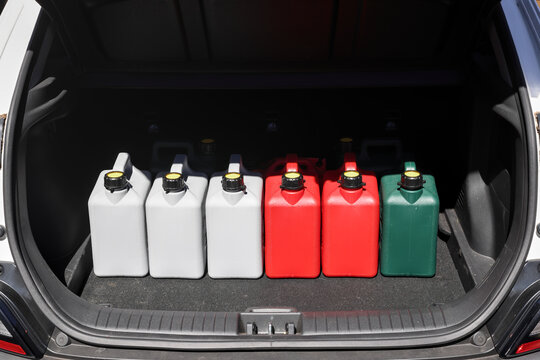 Jerry cans filled with fuel, petrol, gasoline, diesel in car boot.  Panic buying, shortages, soaring prices, empty stock, sold out. Hoarding fuel, safety risks, storing large quantities of flammable