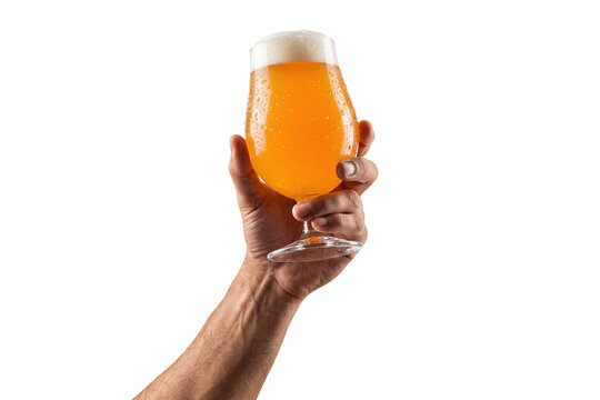 raised male arm holding up a frosty stemmed glass of hazy golden craft beer isolated on a transparent background