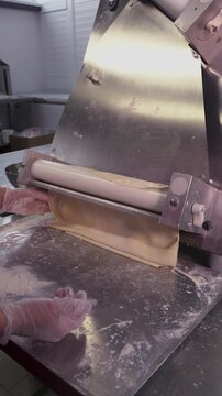 Roll out the dough mechanically. Vertical video about homemade pastries, cooking and confectionery.