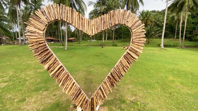 Heart-shaped bamboo decoration on a tropical island beach in Thailand, romantic travel concept, love symbol outdoors.