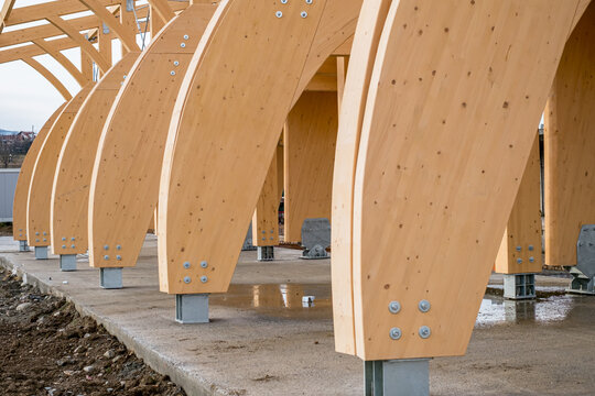 Detail of a modern wooden architecture in glued laminated timber on a blue cloudy sky