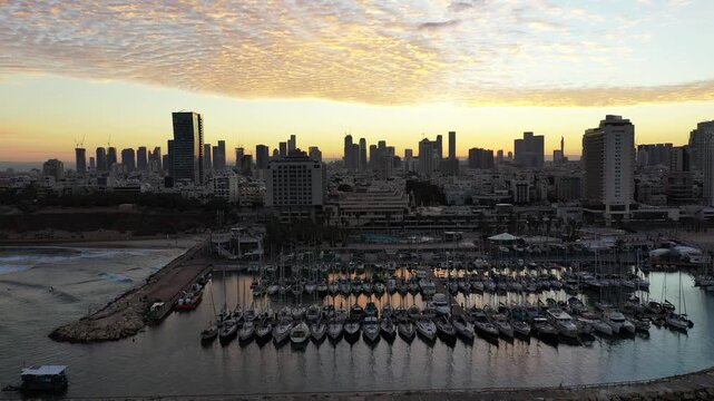 Aerial view of the marina with yachts and the skyline, contrasting the calm waters with the bustling city, Tel Aviv-Yafo, Tel Aviv District, Israel.