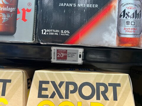 Shelf edge digital price tag for Asahi Super Dry beer cases on display at PAK'nSAVE supermarket showing price and stock information - Auckland, New Zealand, February 8, 2023