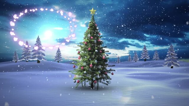 Decorative shining lights against snowflakes falling over christmas tree on winter landscape