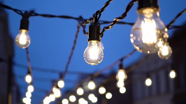 Close-Up of Vintage Edison Bulbs String Lights Glowing at Dusk, Bokeh Effect