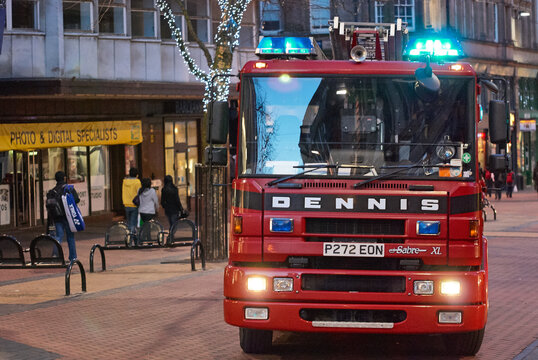 Front view of a Dennis Sabre XL fire engine parked on a pedestrianized street at dusk, Birmingham, West Midlands, England, UK.