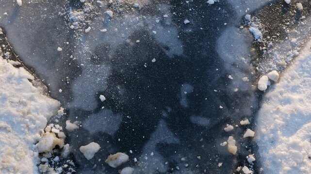 Abstract shapes of nature, air bubbles moving under ice in winter, flowing with current.