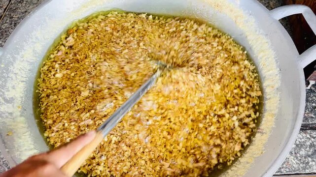 A close-up image of minced garlic frying in piping hot oil, bubbling violently until it turns golden brown and crispy. This captures the beautiful texture, movement, and color of this traditional Th