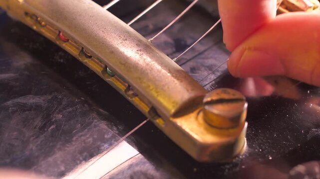 Close up of replacing electric guitar strings, restringing process, instrument maintenance, musician setup and repair concept.