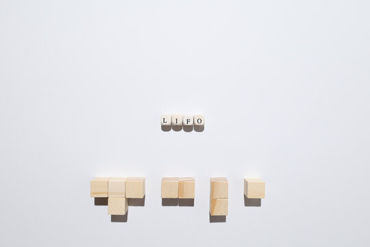 LIFO concept illustrating last-in-first-out inventory method using wooden blocks and letter tiles.