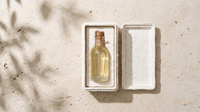 Minimalist glass oil bottle in sustainable recycled paper packaging.