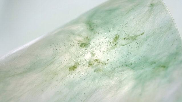 Macro texture of green jade stone with white marble veins.