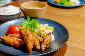 Fototapeta premium 食卓に並ぶ唐揚げ定食と背景の料理