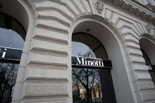 Vienna, Austria- Feb 21, 2026: The elegant facade of Minotti store showcases intricate architectural details. Large arched windows reflect surrounding trees, emphasizing luxury and style.