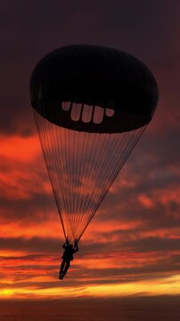 Man flying with parachute high in the sky as silhouette appears against glowing sunrise horizon