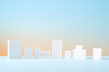 Fototapeta premium Whimsical collection of white miniature building models, representing a stylized cityscape, stands against a soft blue and orange background.