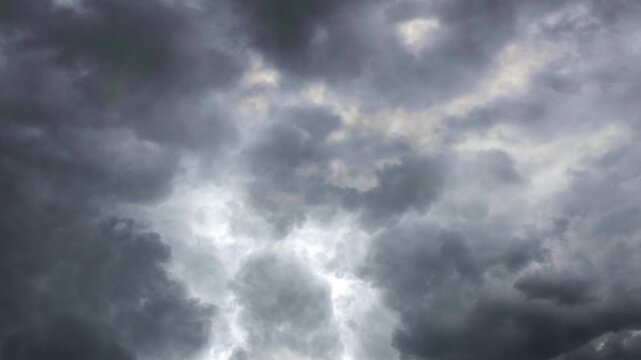 Dramatic dark storm clouds moving across grey sky during overcast weather in cinematic time lapse motion