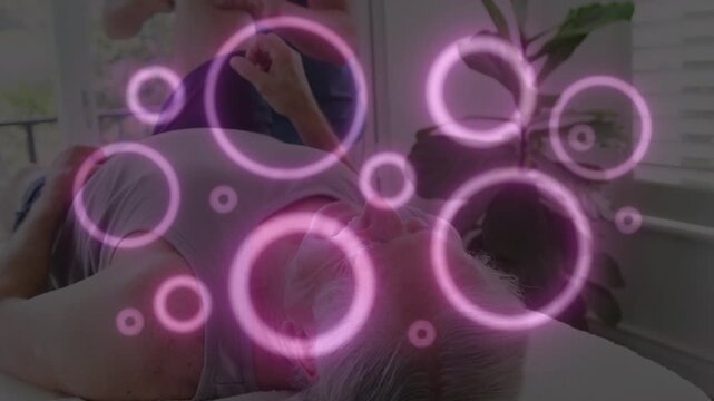 Animation of circles over physiotherapist treating senior caucasian patient