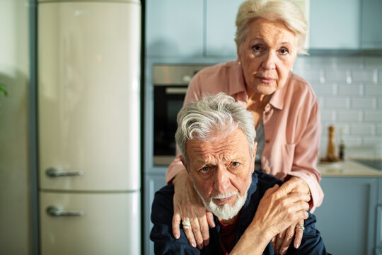 Elderly couple looking concerned in home kitchen