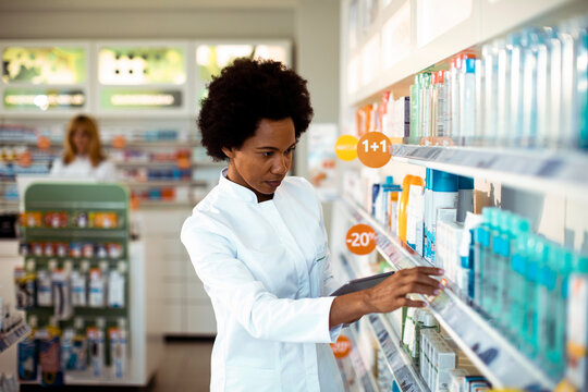 Pharmacist organizing products in modern pharmacy
