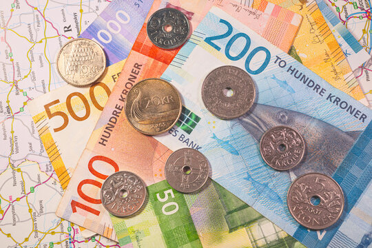 Scandinavian currency Swedish krona banknotes and coins on travel map representing economy and tourism.
