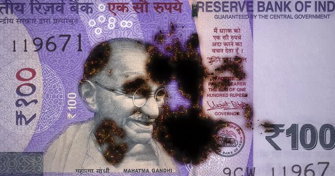 100 rupees of India banknote with smoldering and slowly burning from the glowing edge, Indian paper money, burning rupee banknote turning to ash, inflation, loop footage