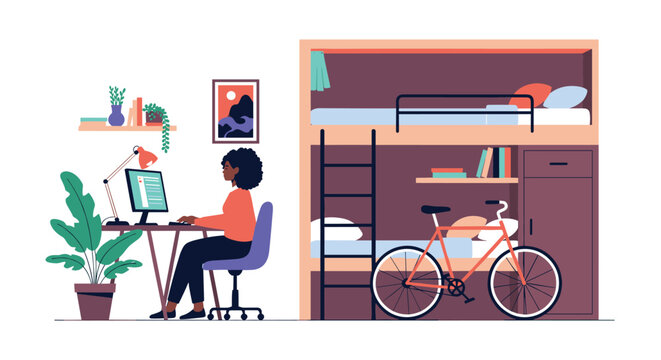 Young African American woman works on a computer in a student dormitory room featuring a bunk bed and a bicycle.