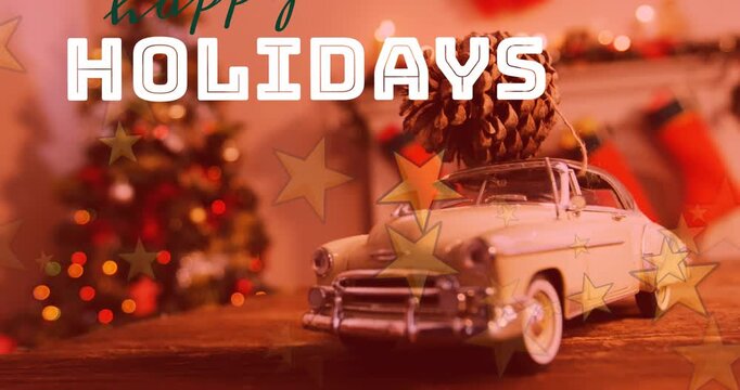 Animation of happy holidays text banner and stars against pine over a toy car on wooden table